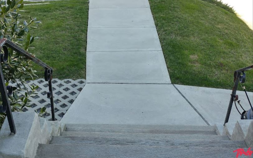 A concrete walkway with stairs leading up to it A concrete walkway with stairs leading up to it