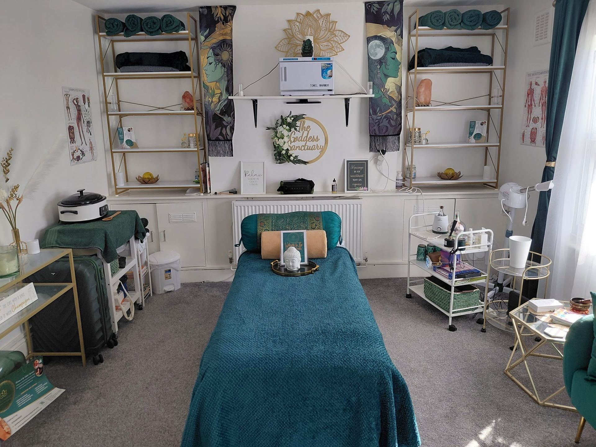 Cozy teal bedroom with twin shelves, white walls, a bed, and decorative plants and lamps