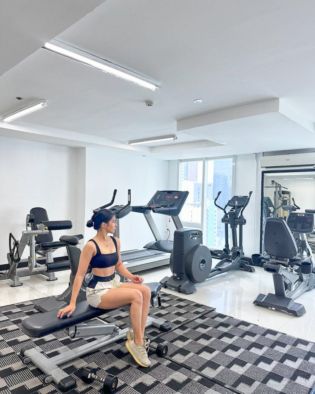 Woman resting on gym bench at Y2 Residence Hotel fitness center Makati