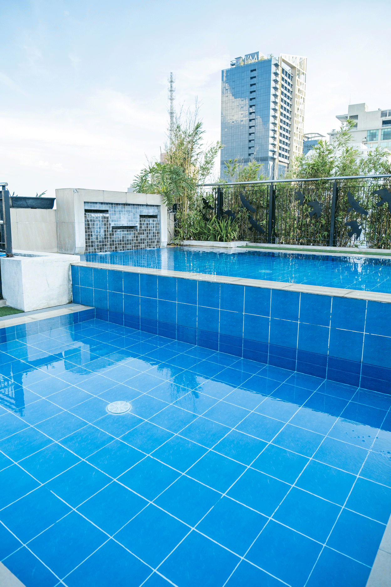 Rooftop pool with blue tiles and city skyline at Y2 Residence Hotel Makati