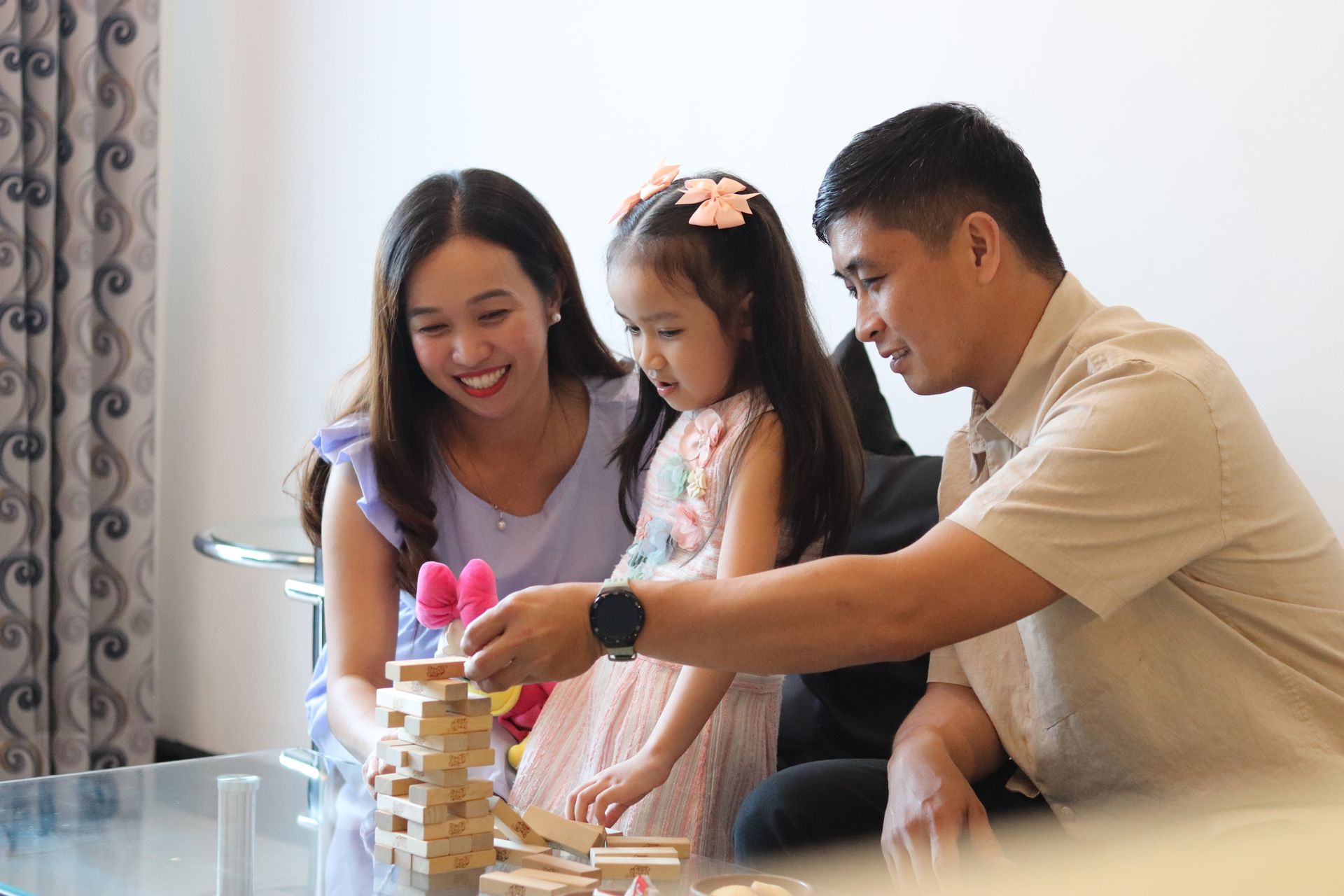 Family playing a wooden block-stacking game on the coffee table of a unit at Y2 Residence Hotel Makati
