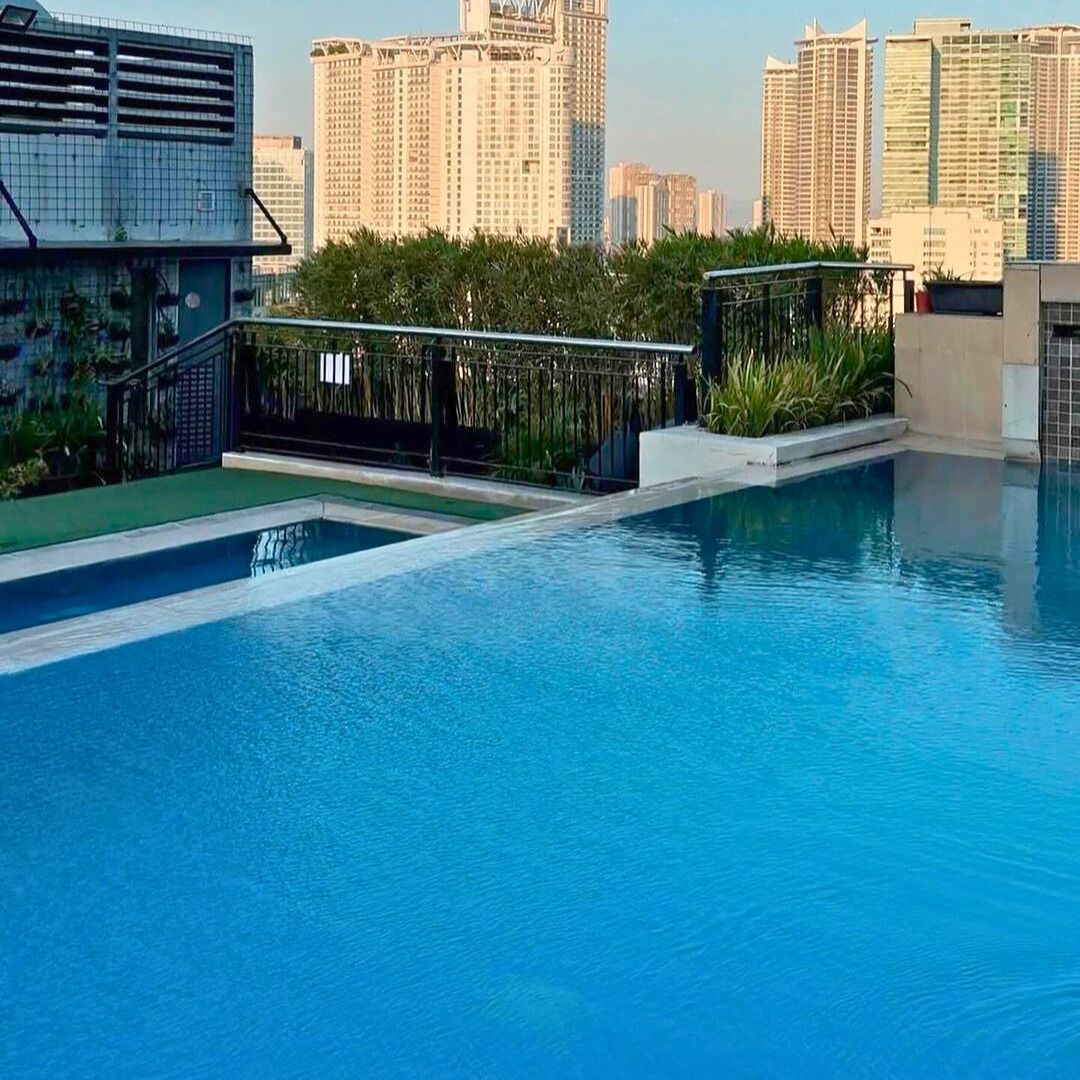 Rooftop pool with city views at staycation hotels makati with pool.
