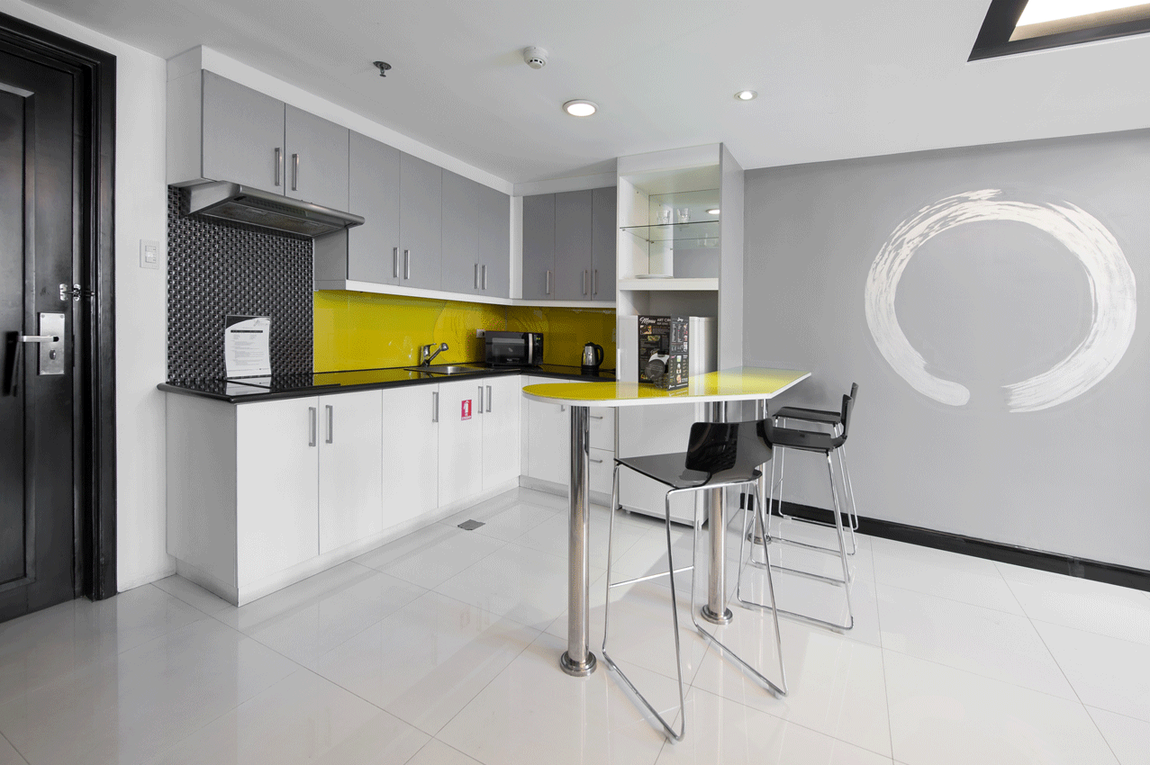 Full kitchenette and dining area in a One Bedroom Deluxe at Y2 Residence Hotel, Poblacion Makati