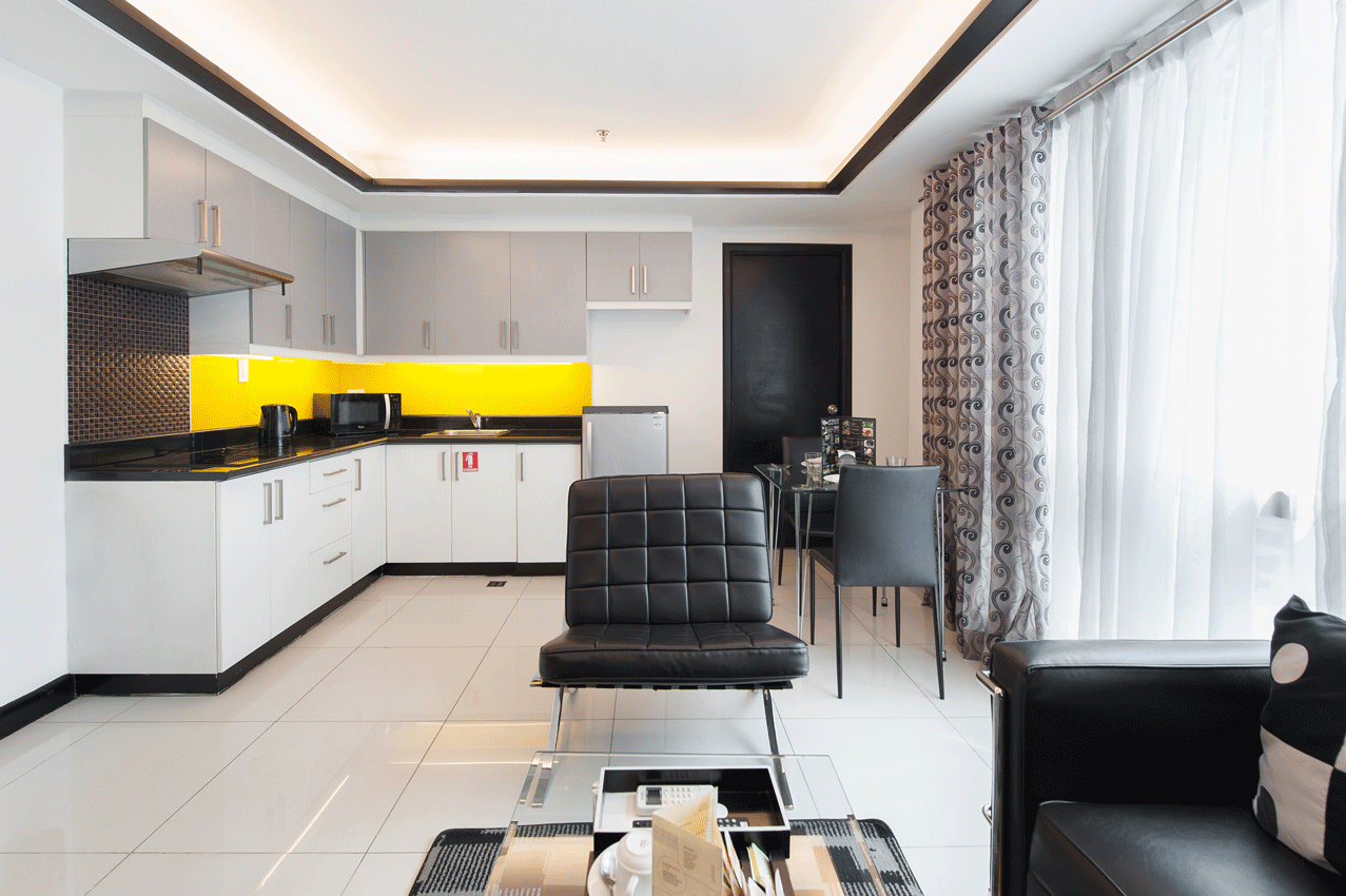 Modern bedroom with yellow accent lighting at family staycation makati hotel.