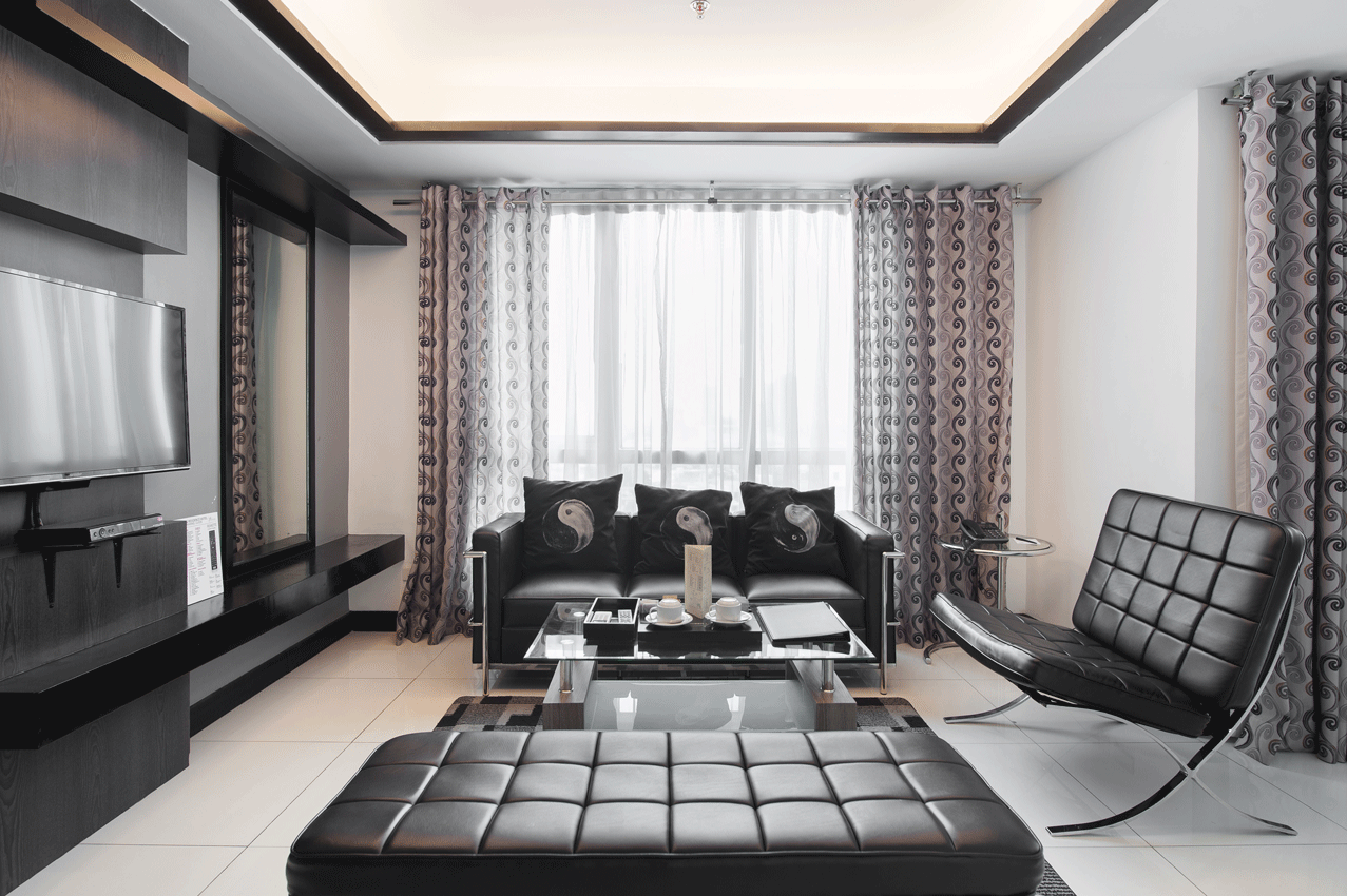 A living room with a couch a chair and a coffee table in a residence hotel in Makati