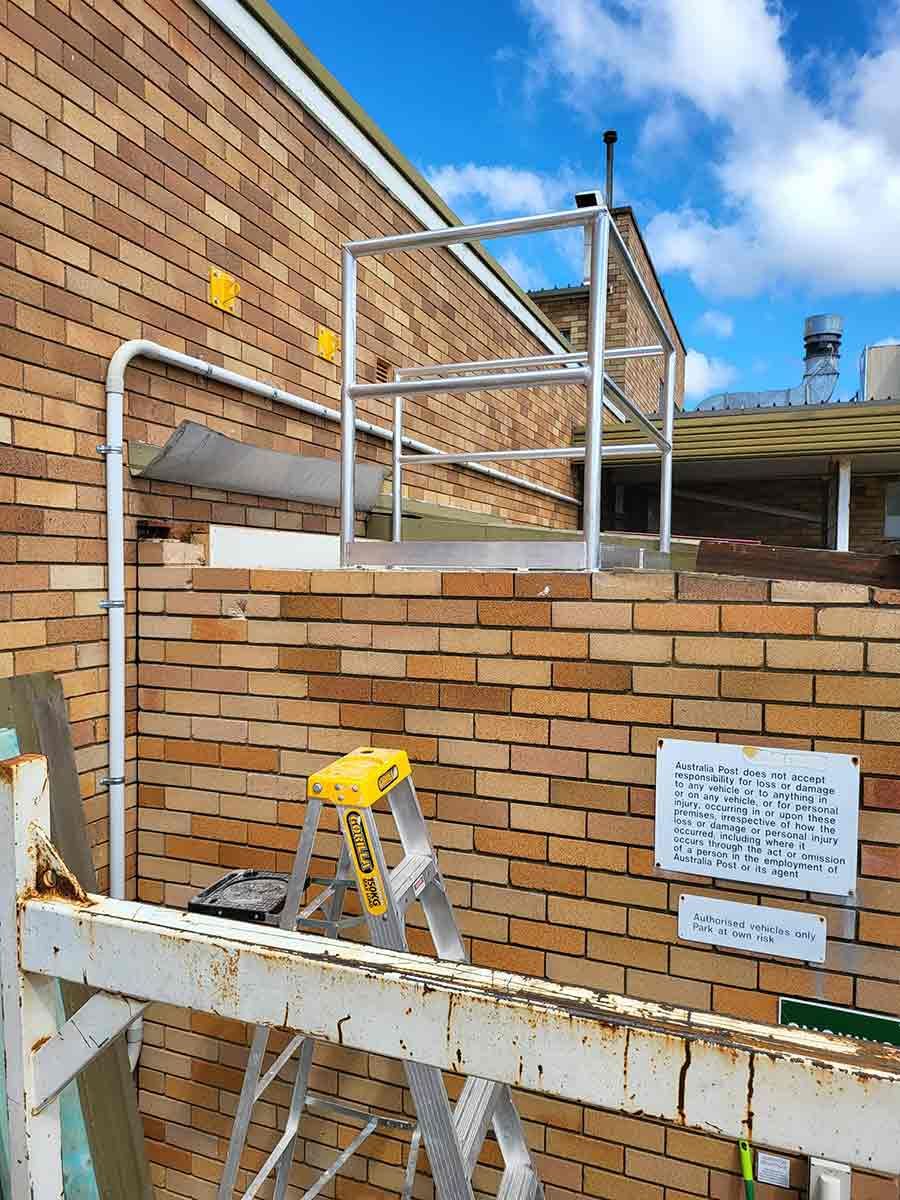 A Ladder is Leaning Against a Brick Wall With a Railing — SCF Industries Pty Ltd in Albion Park Rail, NSW