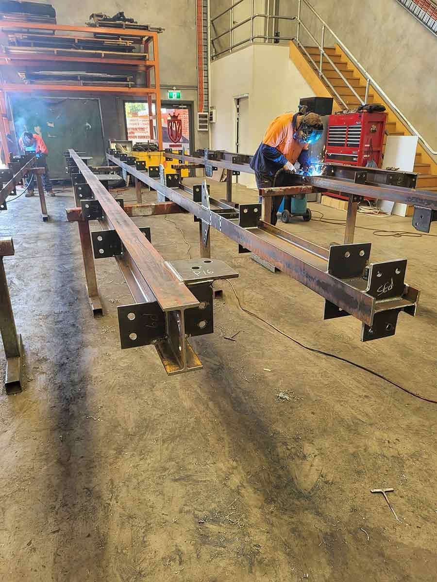 A Man is Welding a Metal Structure in a Factory — SCF Industries Pty Ltd in Albion Park Rail, NSW