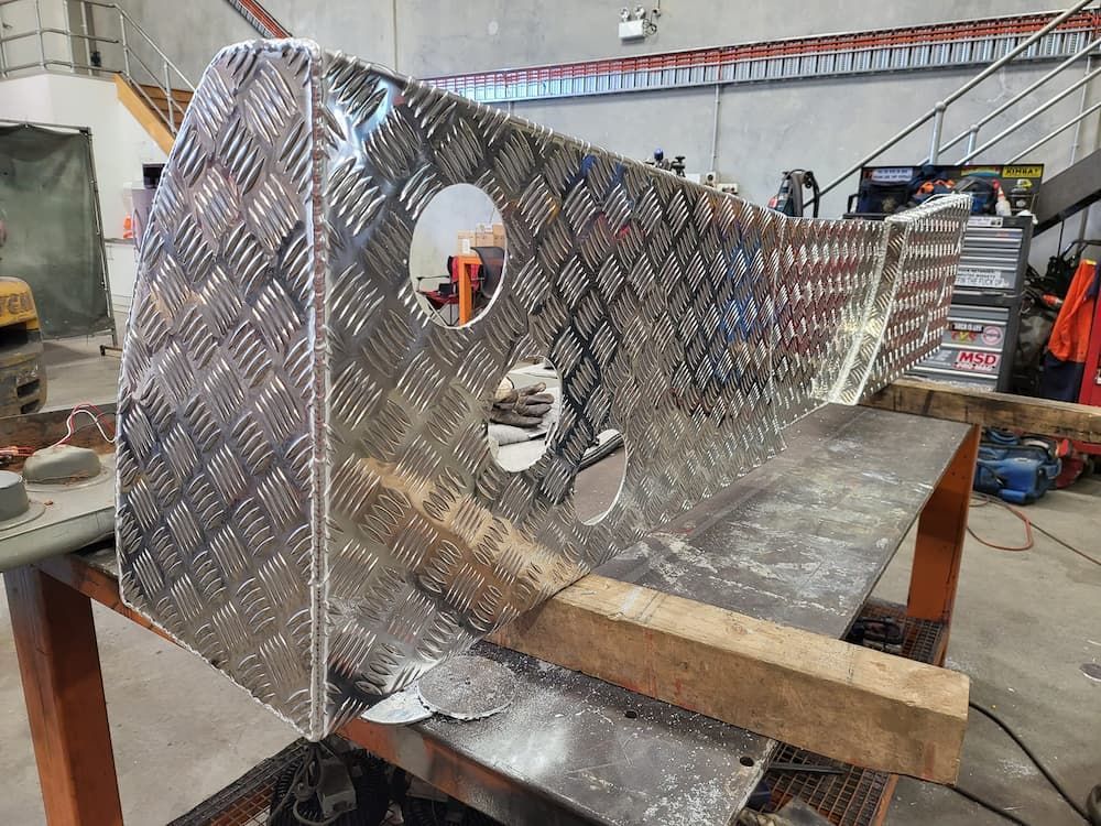 A Piece of Metal is Sitting on Top of a Wooden Table — SCF Industries Pty Ltd in Albion Park, NSW
