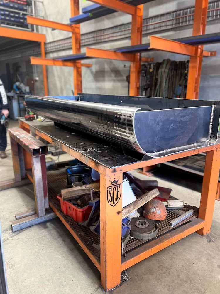 A Large Piece of Metal is Sitting on Top of an Orange Table — SCF Industries Pty Ltd in Shellharbour, NSW