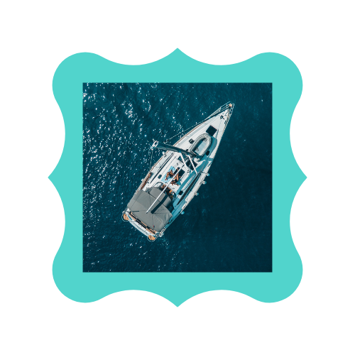 An aerial view of a sailboat in the ocean.