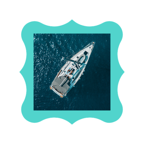 An aerial view of a sailboat in the ocean.