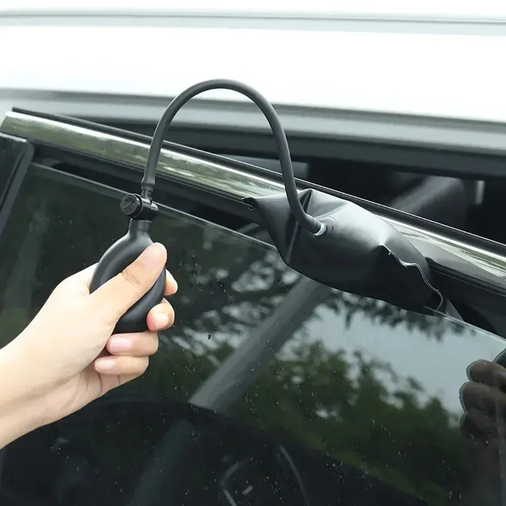 Hand turning a key in a black car door lock