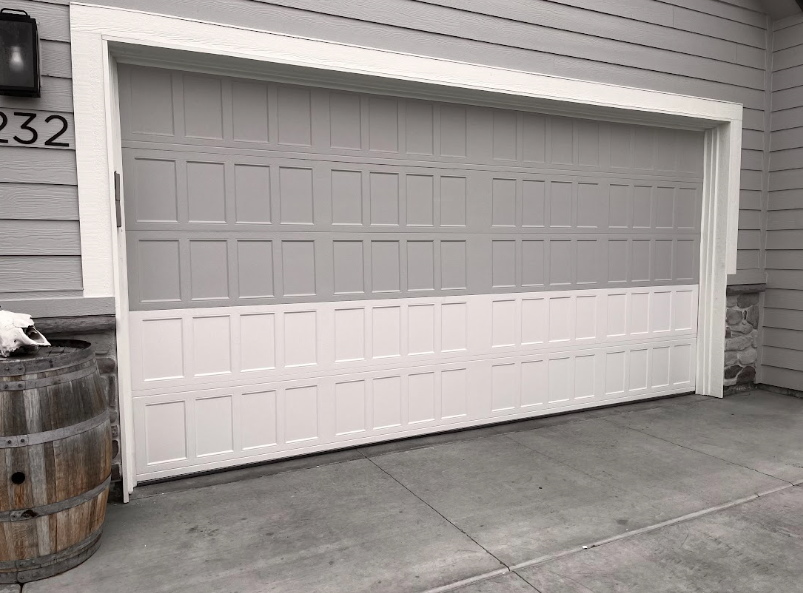 White residential garage door with horizontal panels and a concrete driveway.