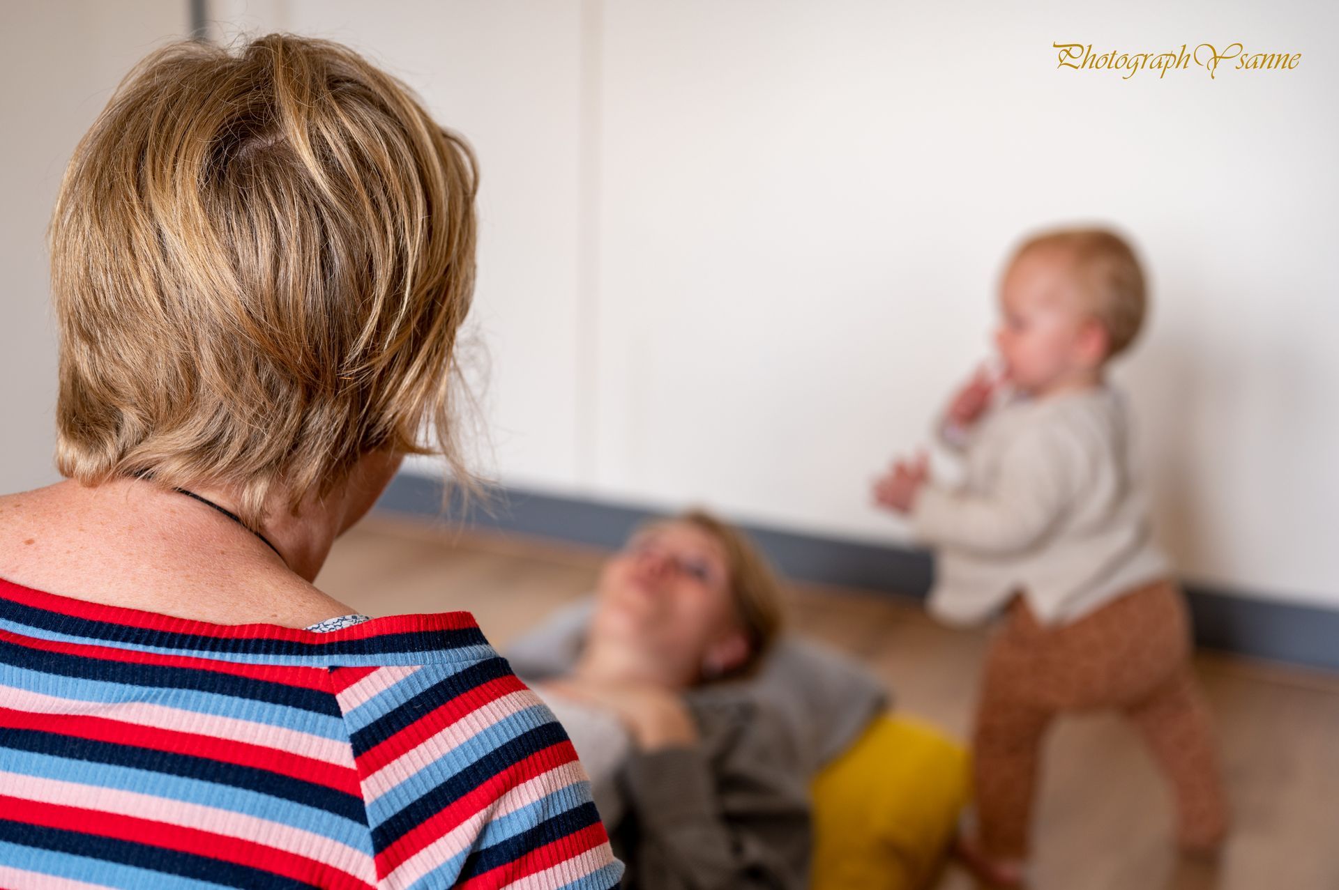Een vrouw in een gestreept shirt kijkt naar een baby