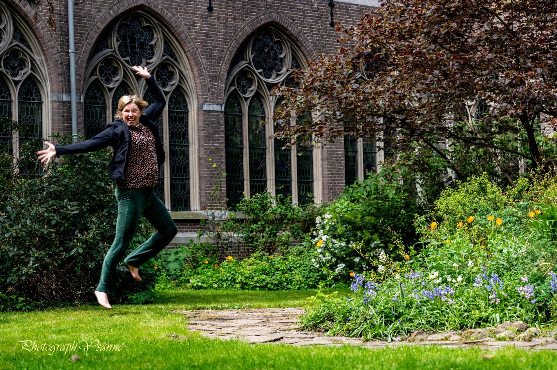 Een vrouw springt in de lucht voor een kerk