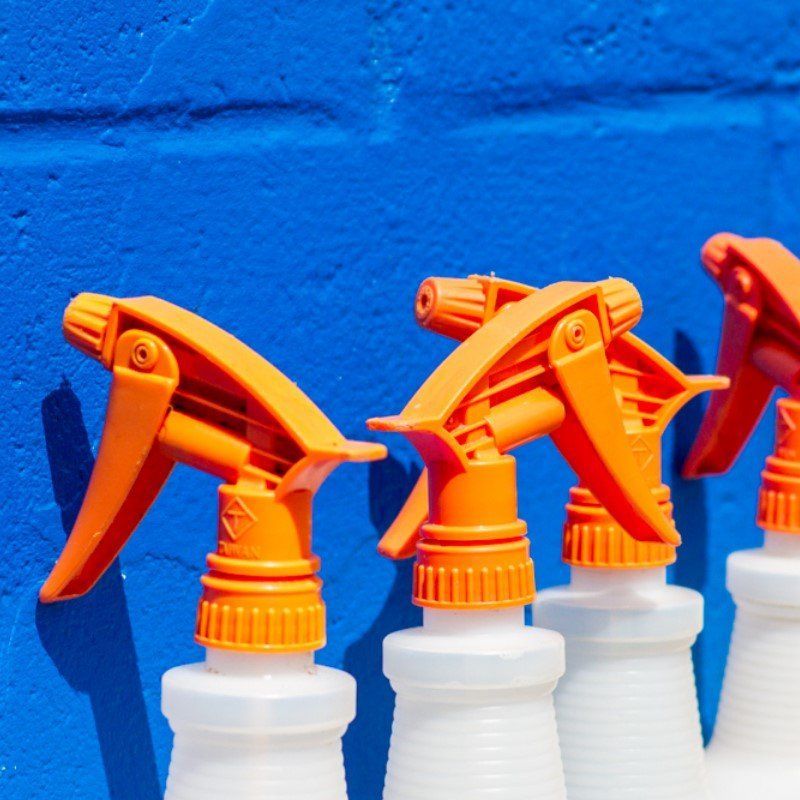Car Wash Detailing - cleaning spray bottles lined up against blue wall