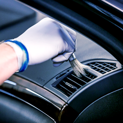 White gloved employee cleaning an air vent - Detail Menu - Forest Carwash & detail in dallas texas