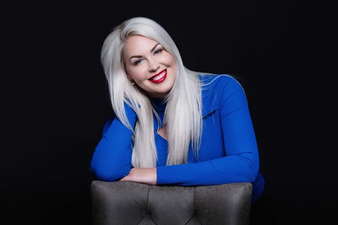 AnneMarie Krainich, owner Ottalaus Salon, in a blue shirt behind a chair