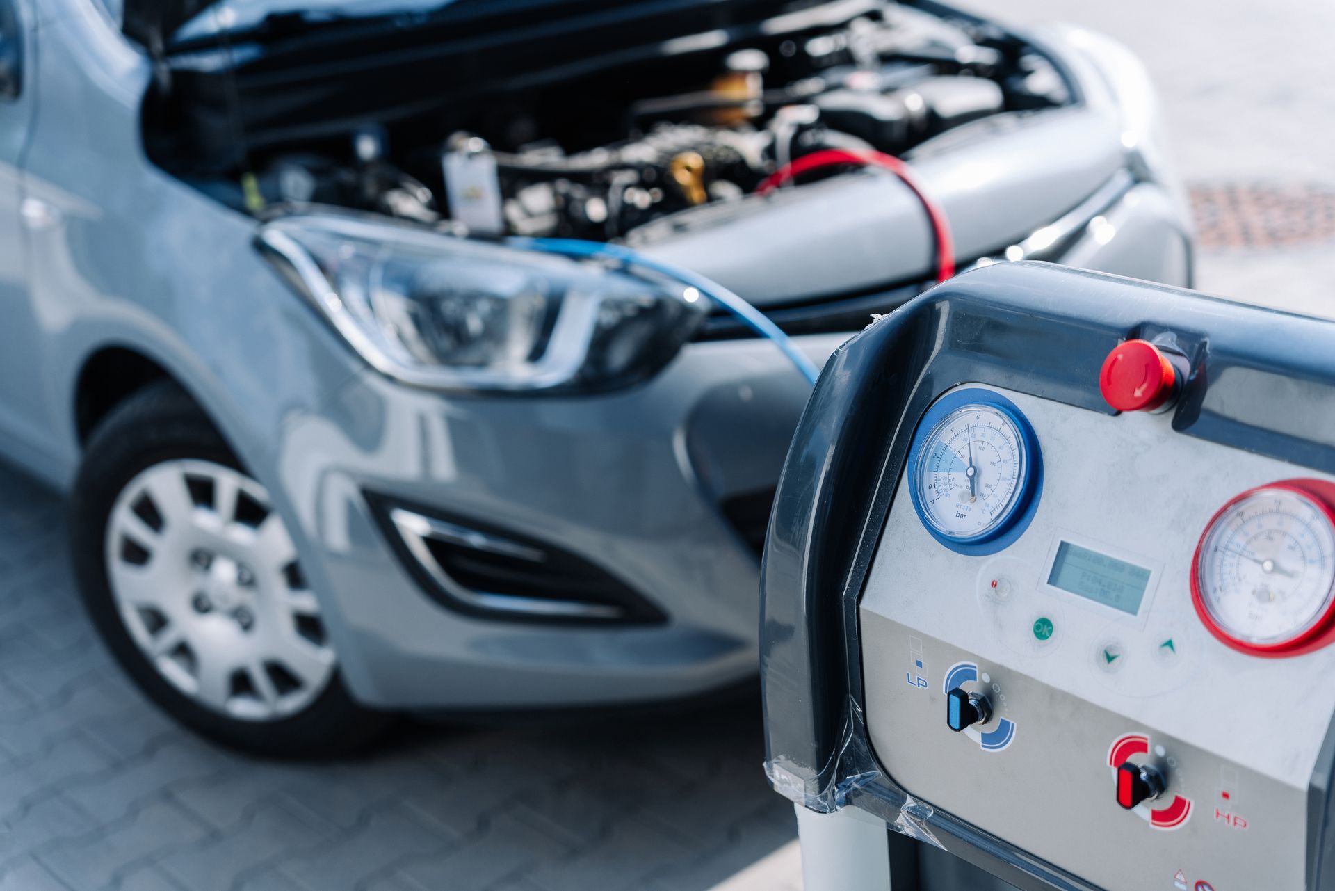 Car engine testing setup with diagnostic gauges connected to an open hood