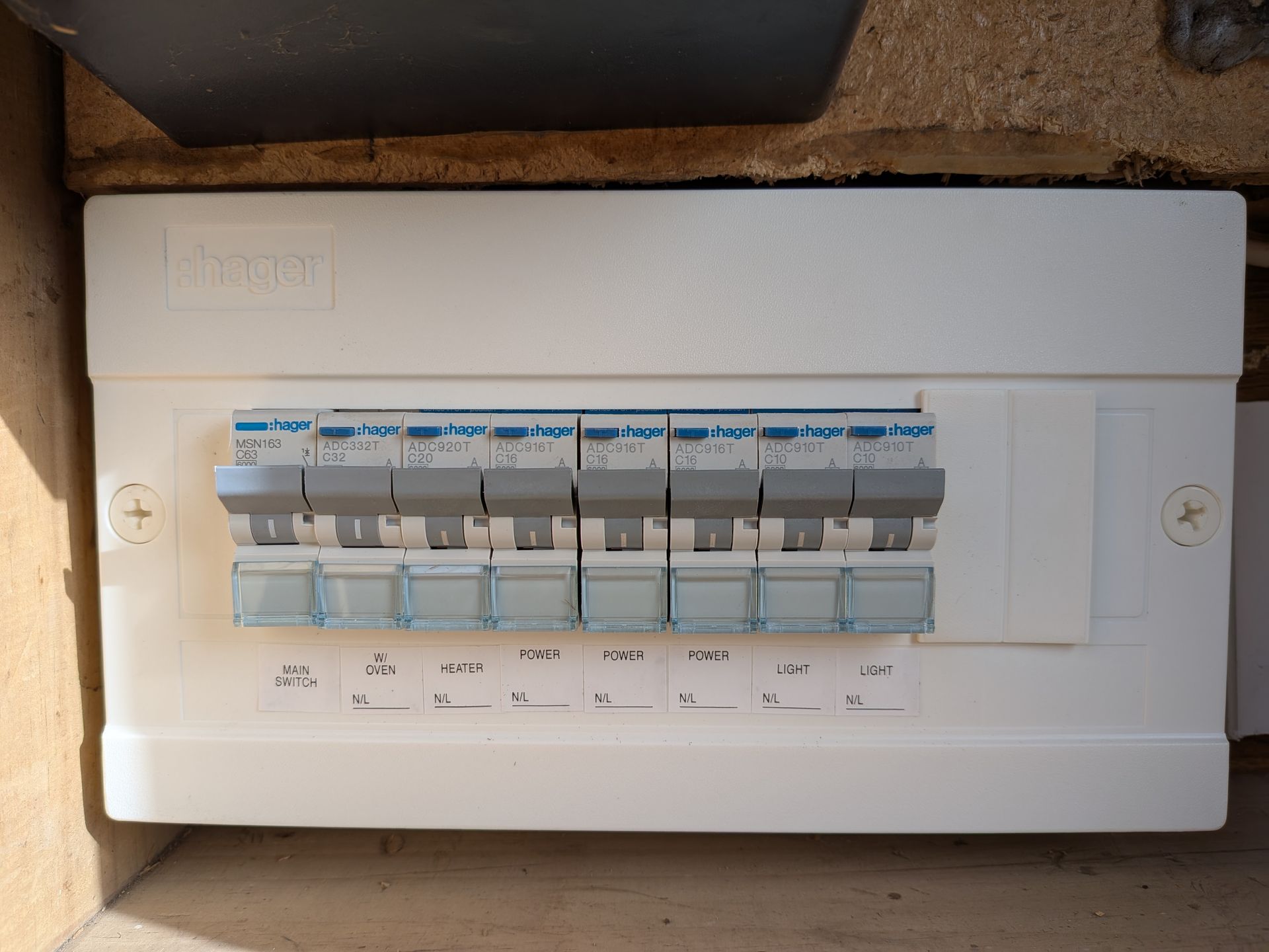 White electrical breaker box mounted on a brick wall, with several circuit breakers. — Ryphen Electrical in Highton, VIC