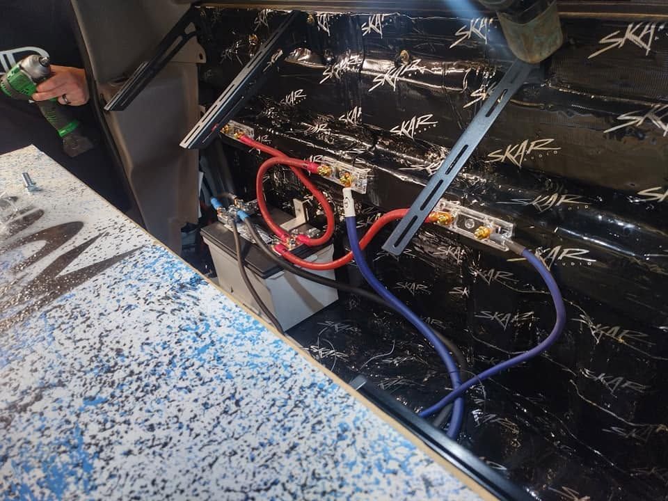 Close-up of blue and red hoses connected to a black machine in a workshop area