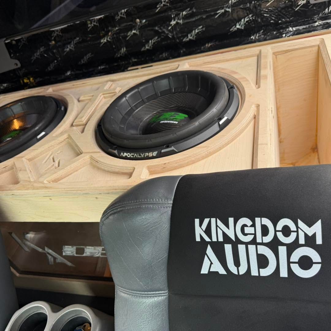 Kingdom Audio car subwoofer enclosure with two large black speakers in a wooden box