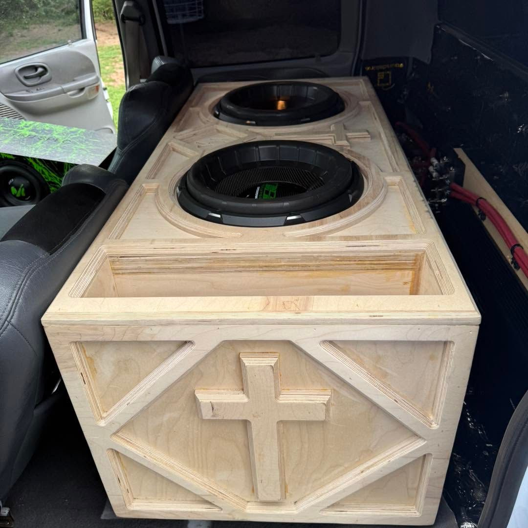 Wooden car audio subwoofer box with two speakers installed in the back of an SUV.