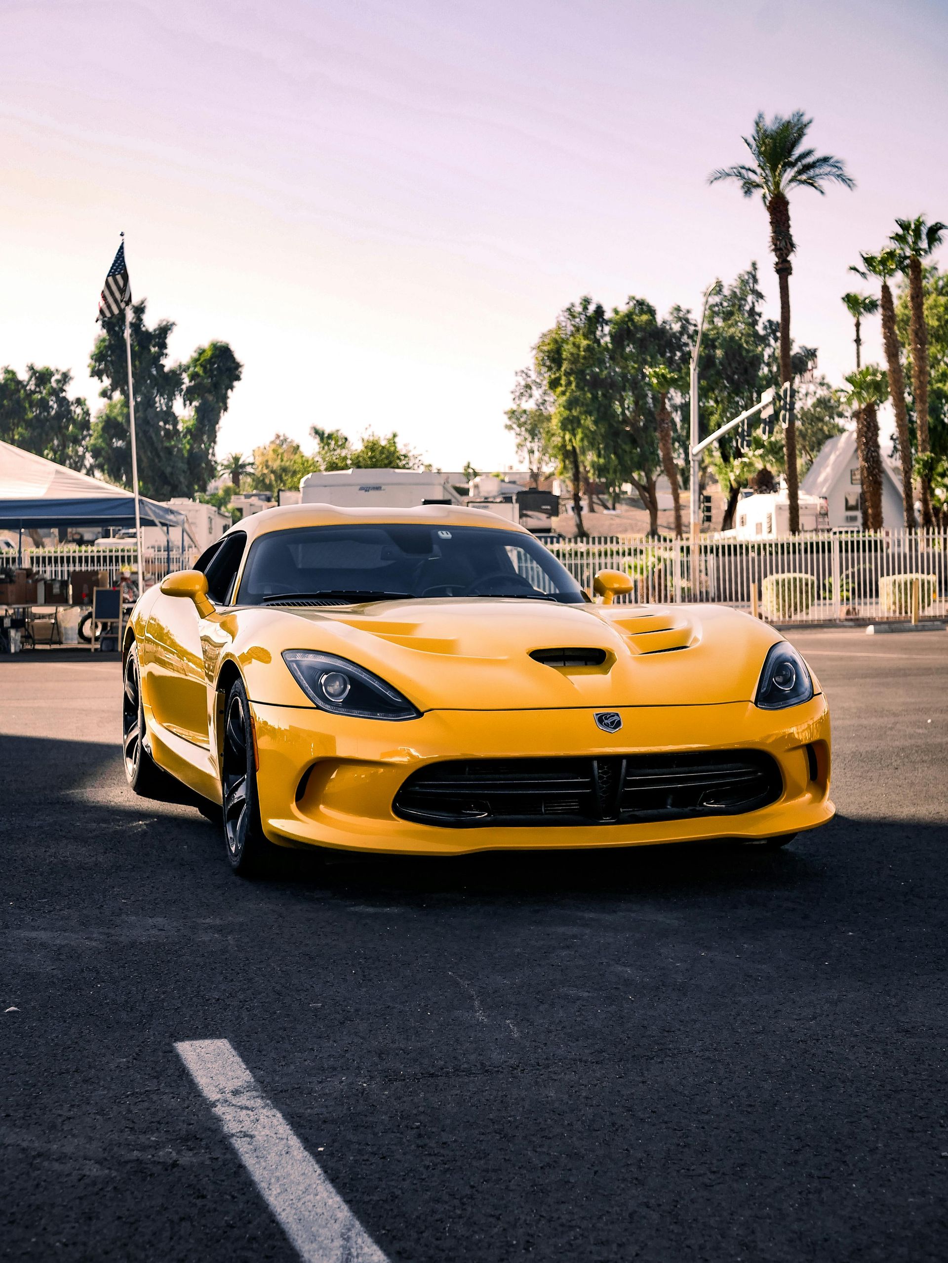Yellow Dodge Viper parked on asphalt, sunny outdoor setting.