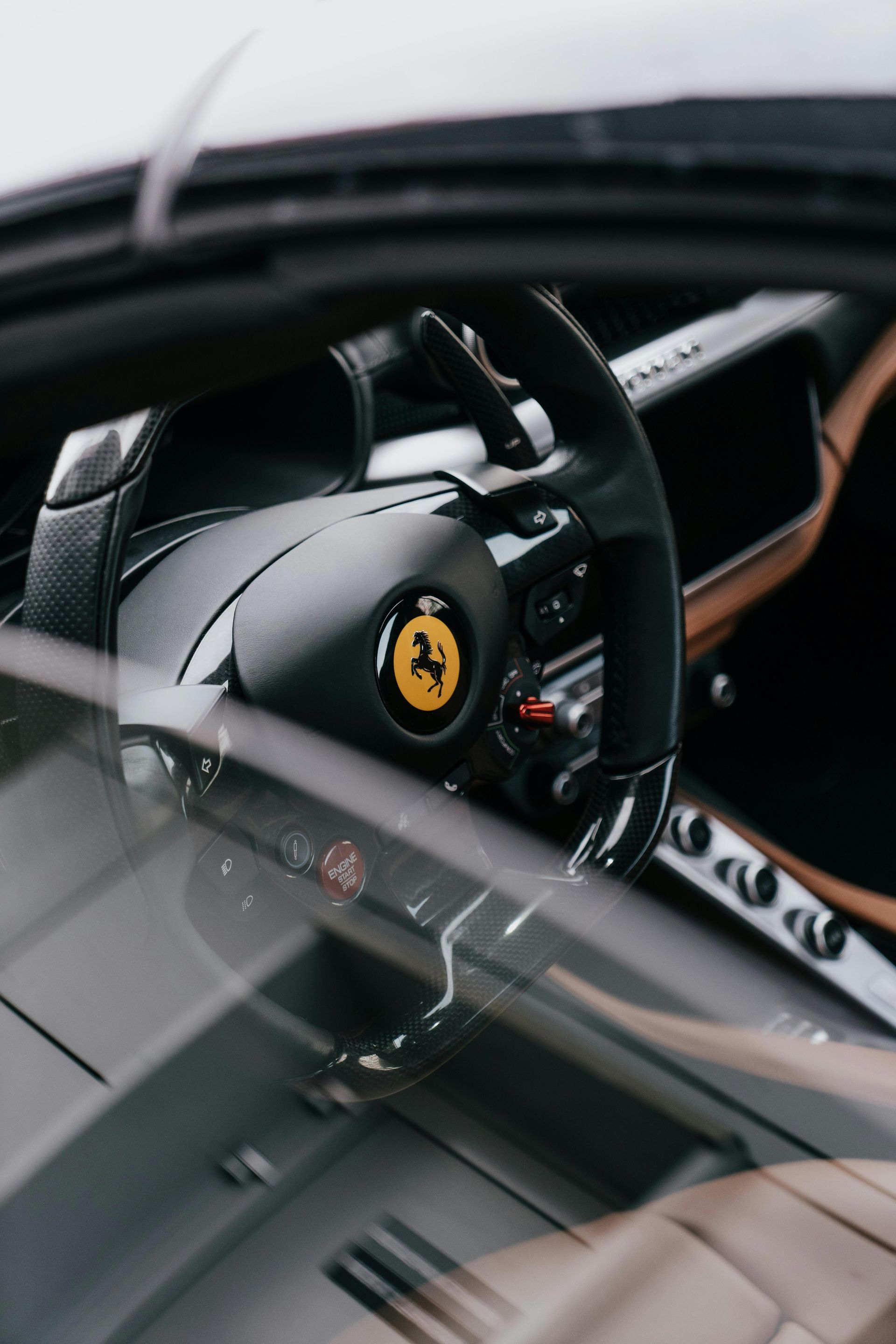 Black Ferrari steering wheel with yellow emblem.