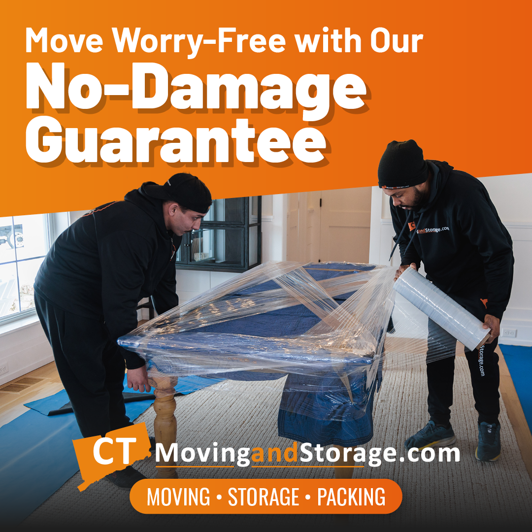 Two movers wrapping a blue table in plastic, orange background with text about a no-damage guarantee.