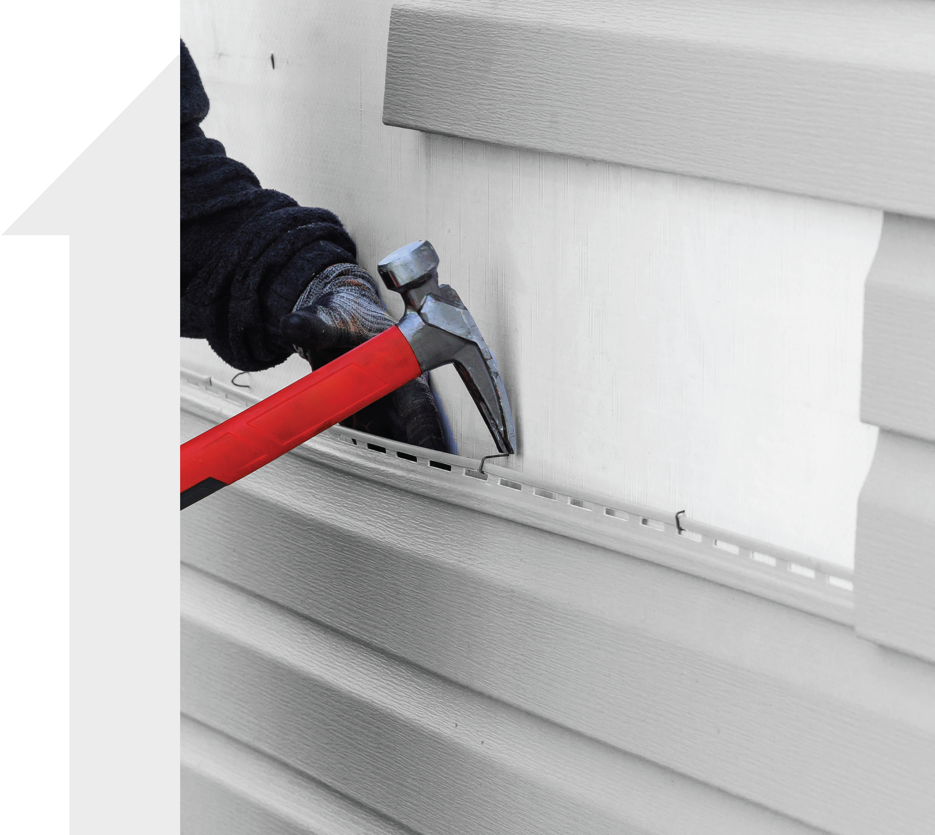 A person is hammering a piece of siding on a wall