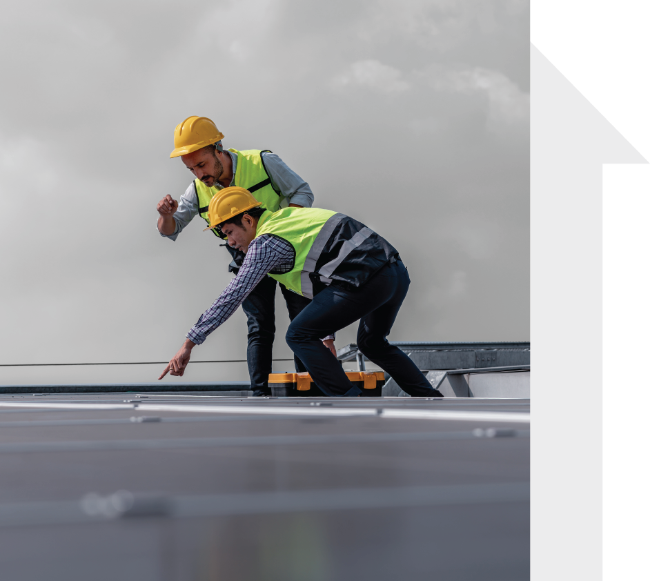 Two construction workers are working on a roof.