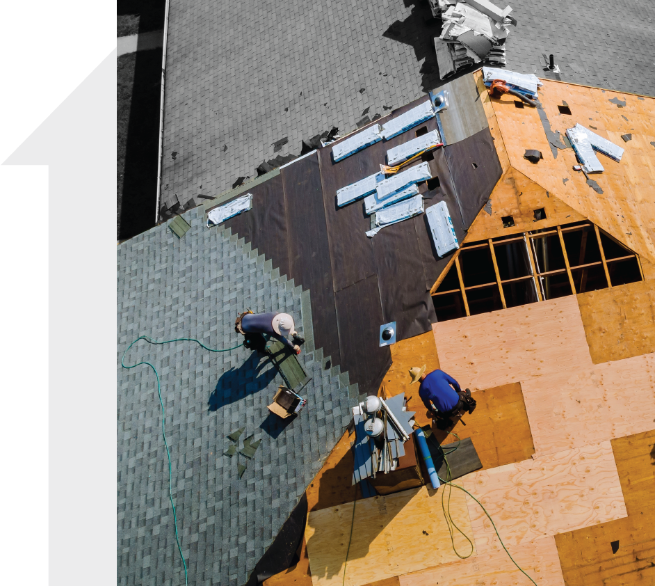 An aerial view of two men working on a roof