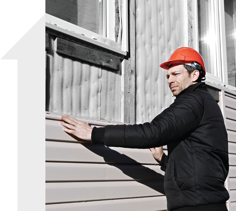 A man wearing a hard hat is standing next to a window.