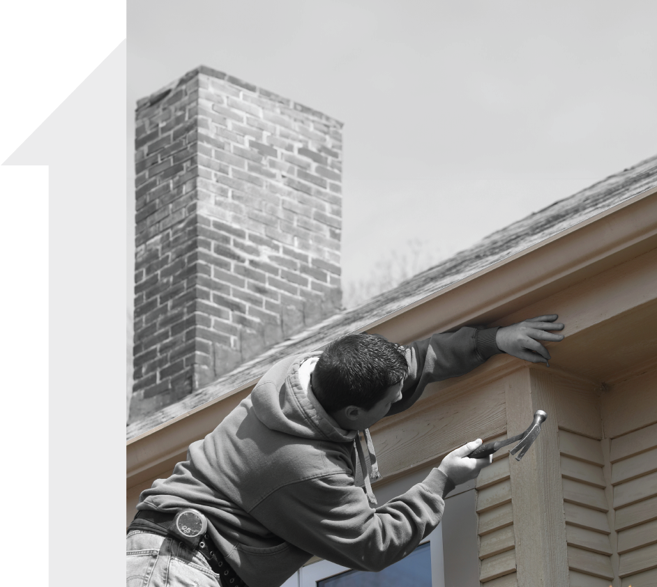 A black and white photo of a man working on a roof