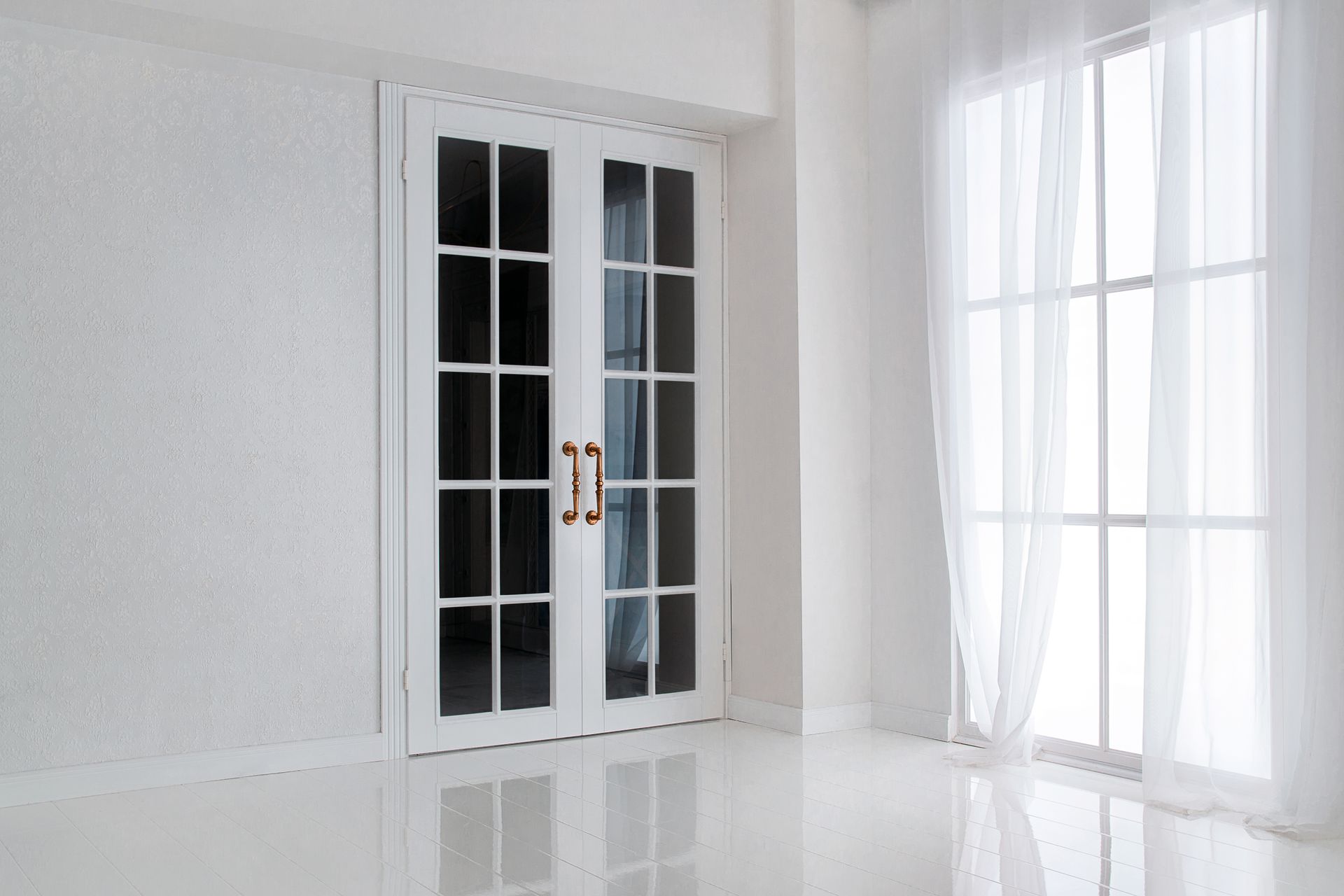 An empty room with two french doors and two windows.