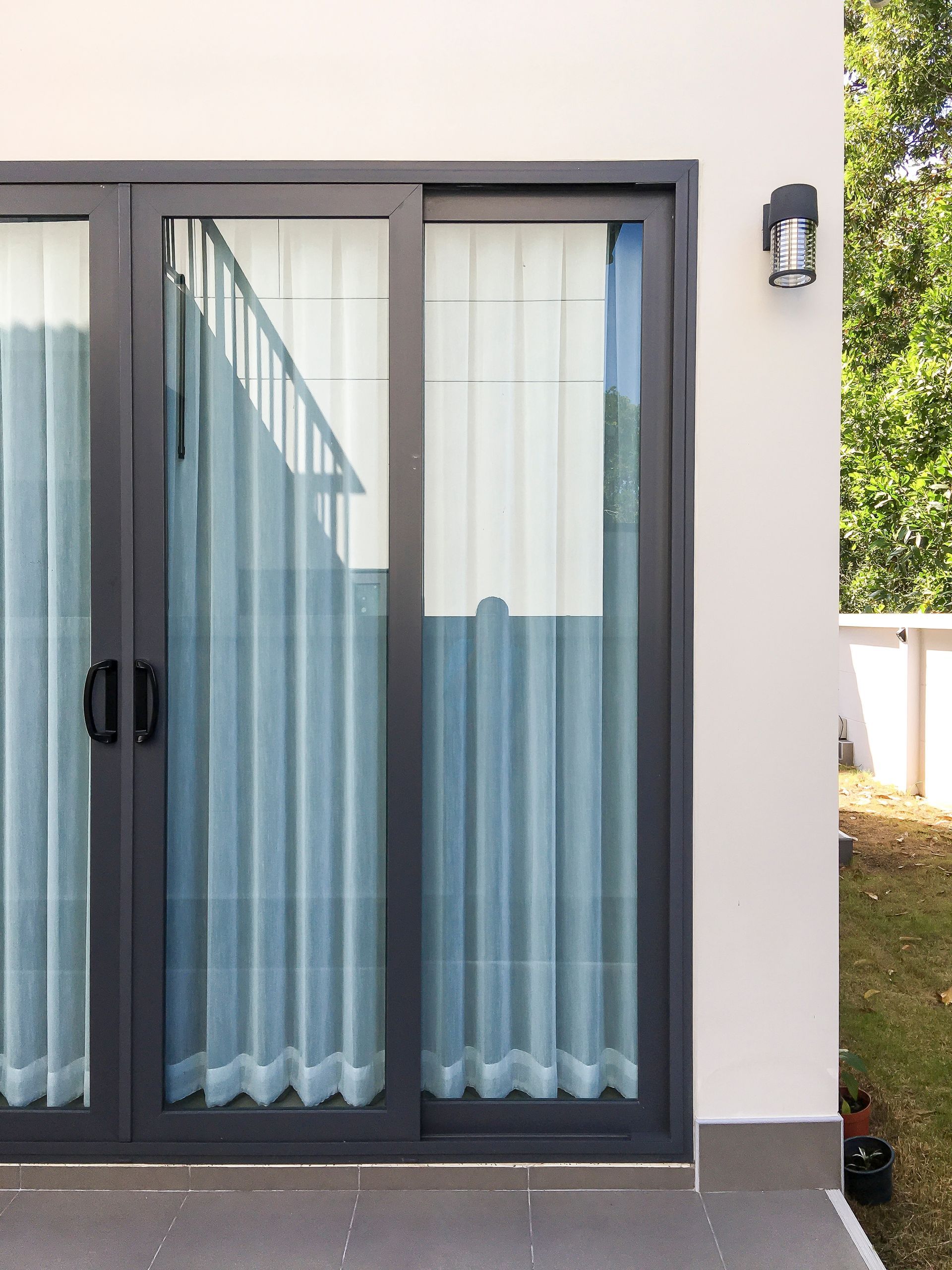 A sliding glass door with blue curtains on it