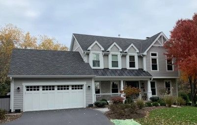A large house with a gray roof and a white garage door.