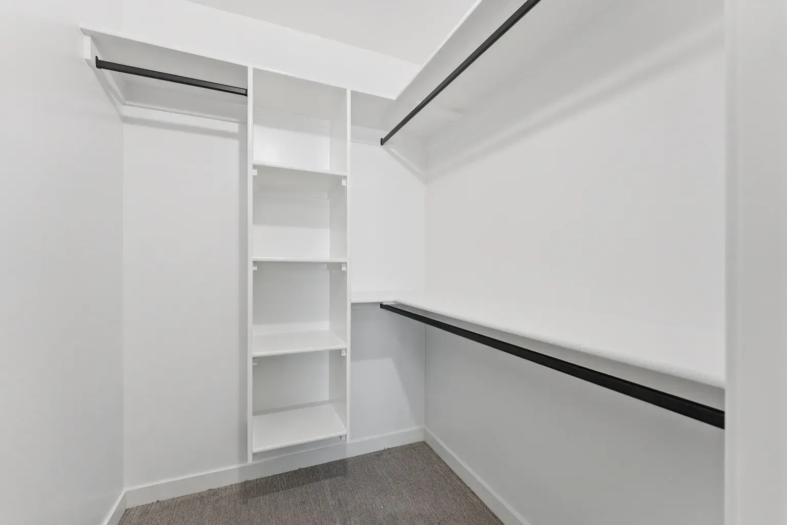 White walk-in closet with built-in shelves and dual hanging rods.