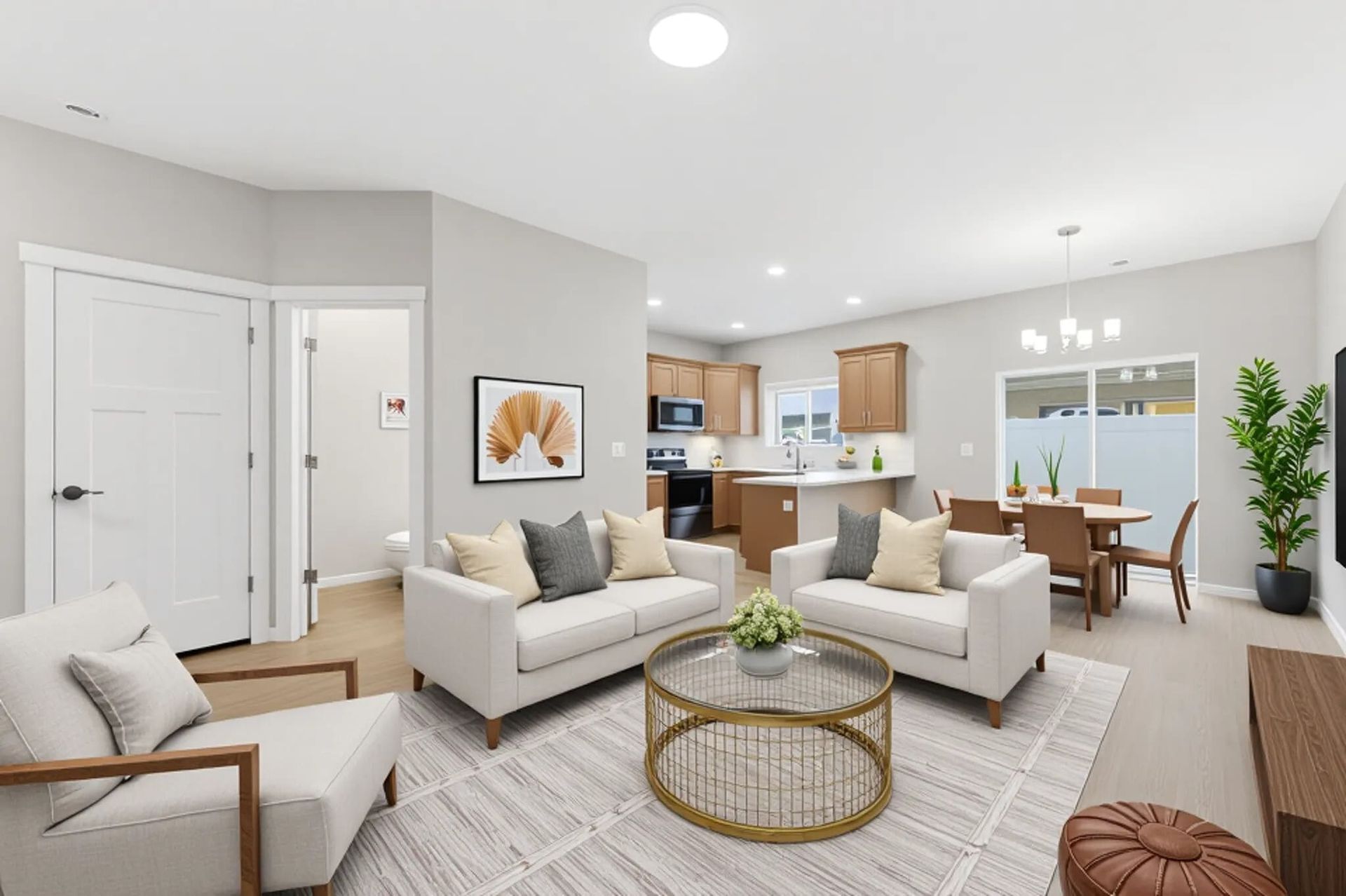 Open-concept apartment living room with beige sofas, round glass coffee table, and a dining area.