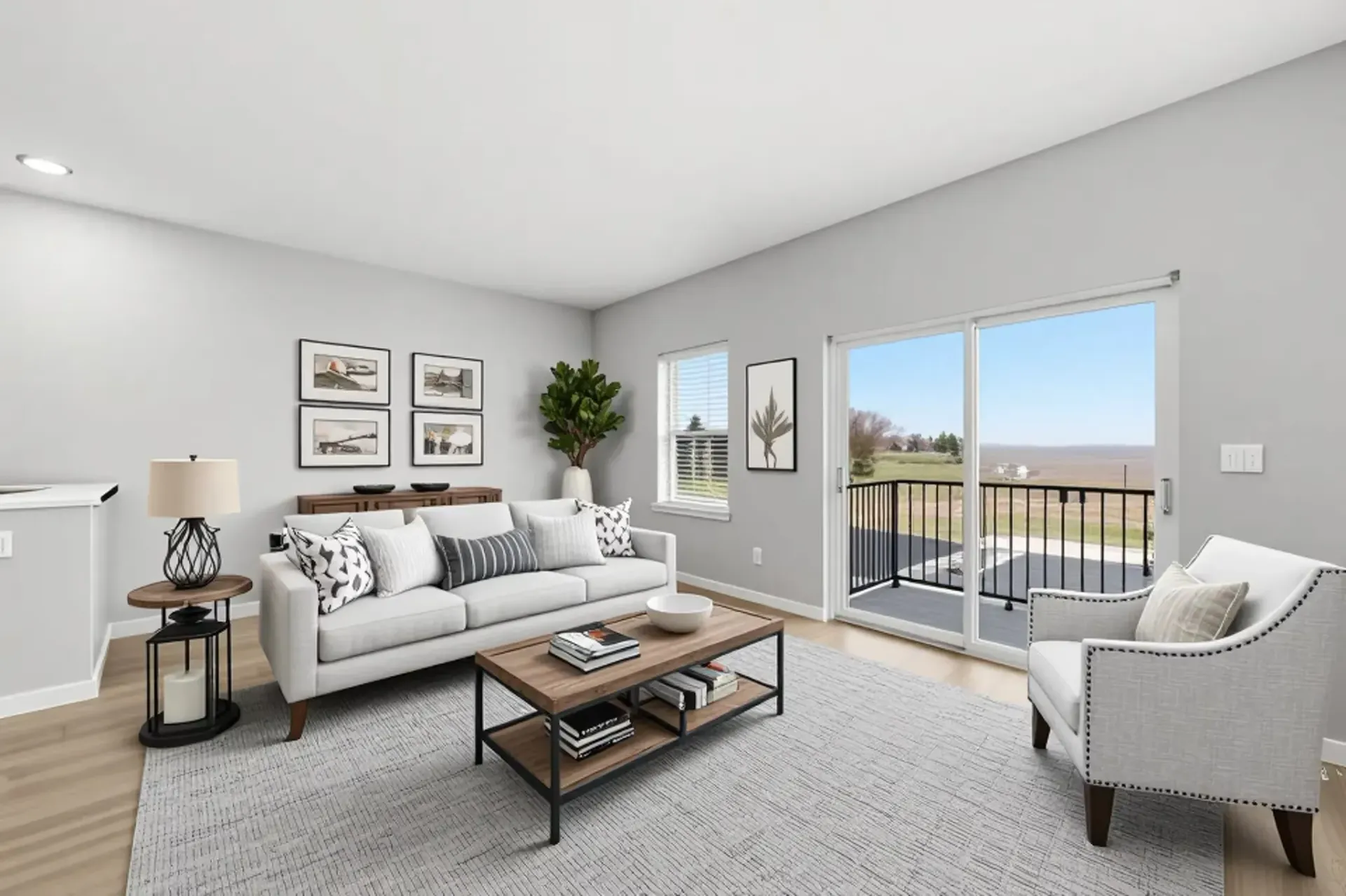 Bright living room with neutral tones, sofa, armchair, coffee table, and sliding glass door to a balcony.