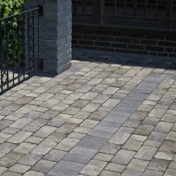 a charlestone driveway with a gate and a brick wall in the background .