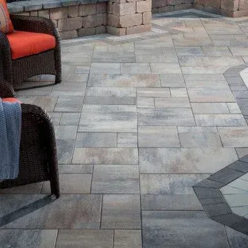 a Dimensions patio with wicker chairs and a blanket on it .