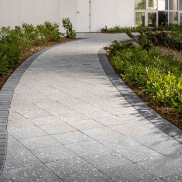 a brick walkway leading to a white building