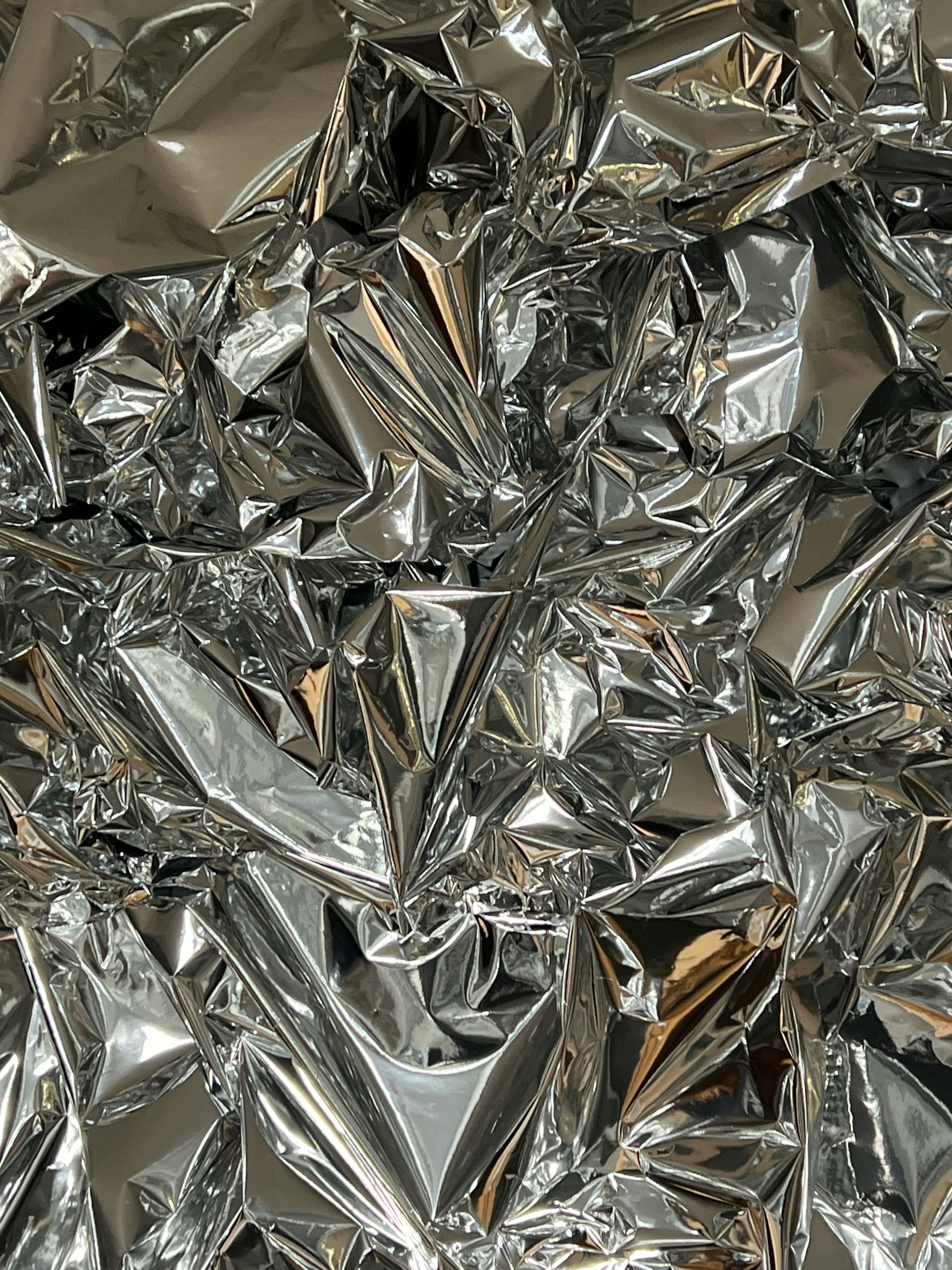 Abstract gray and white metallic surface with smooth curved reflections and flowing lines