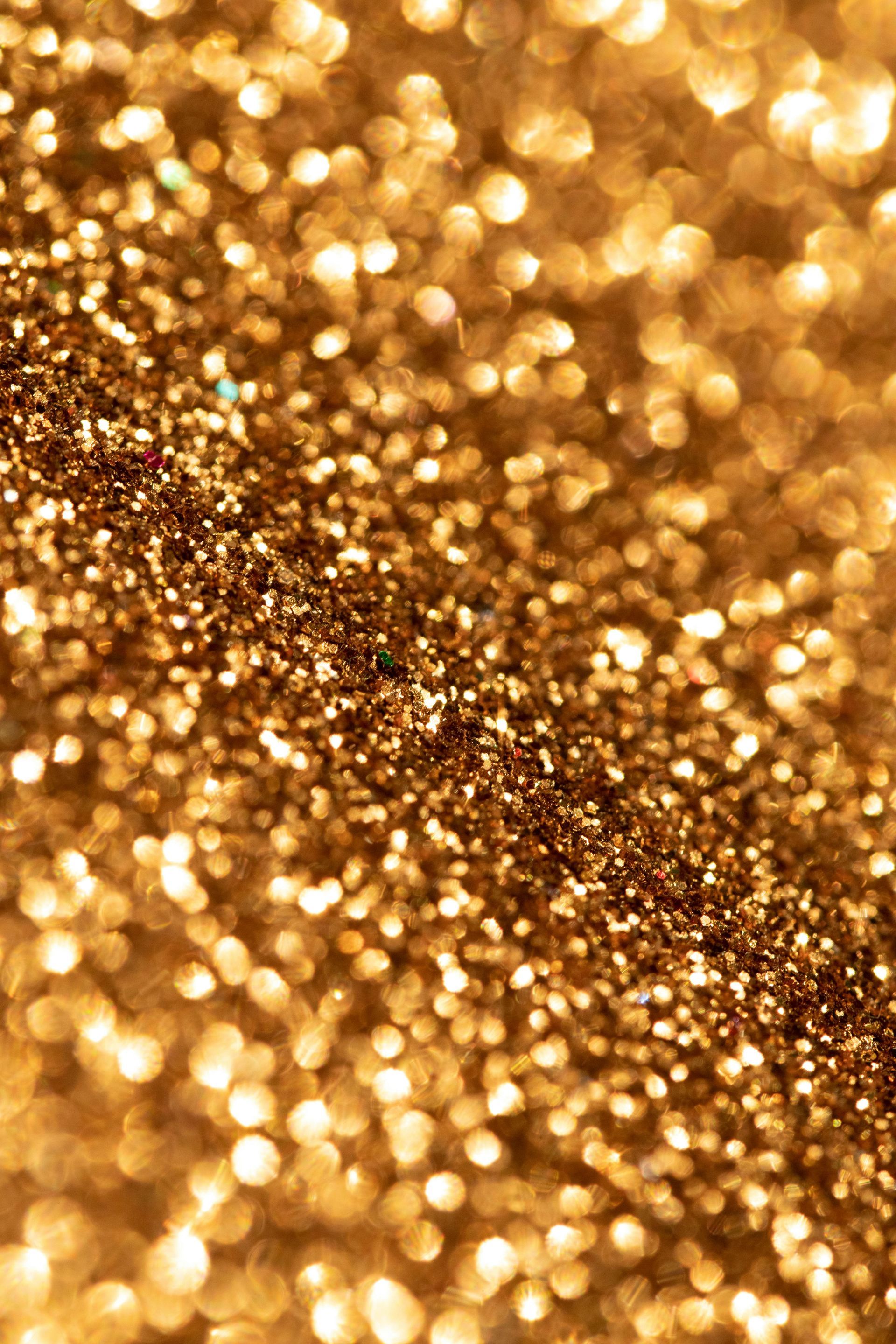Golden glitter texture with sparkling light reflections