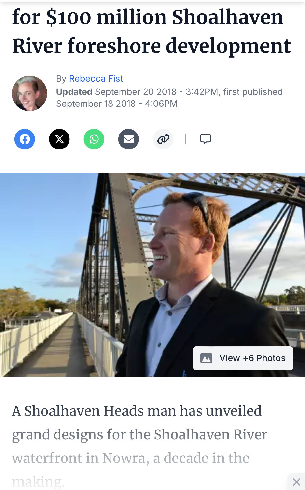 Man in suit smiling, with bridge and river in background, article about Shoalhaven development.