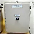 White metal cabinet with a label and black handle in an industrial setting