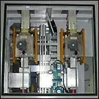Industrial machine components inside a metal cabinet with two side-by-side units and central wiring.