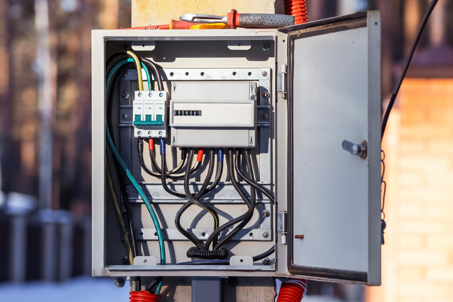 Open electrical control panel with wires and switches mounted outdoors